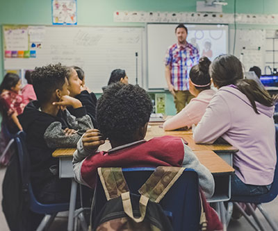 Male teacher in front of the classroom