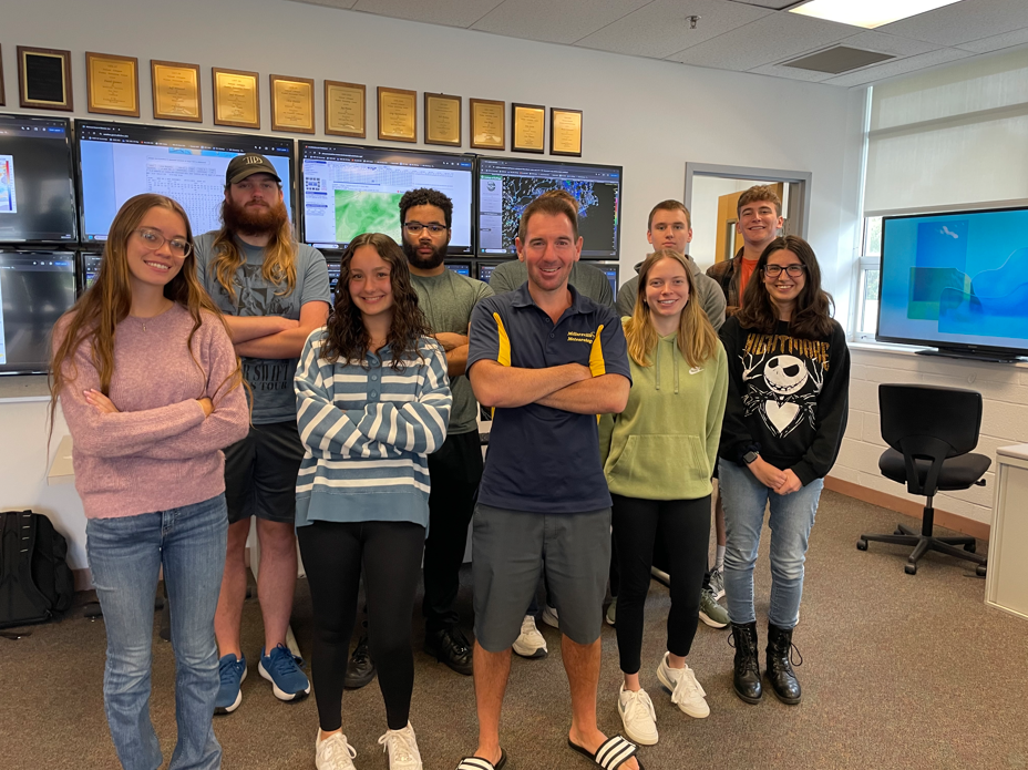 Meteorology students with WIC Director Kyle Elliott in front of the map wall.