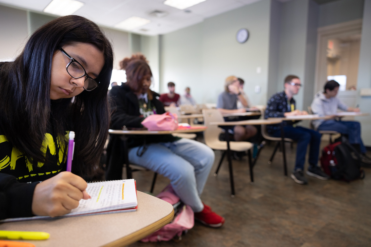Group of students sit in class and take notes
