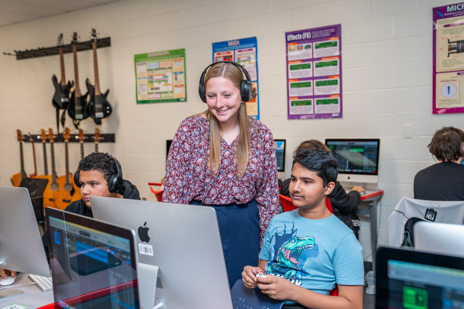 Teacher standing next to student giving instructions