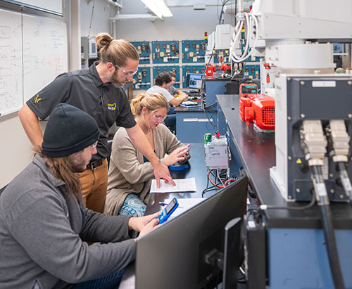 Professor teaching students in a technology lab
