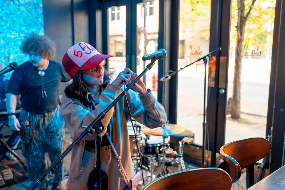A young woman sets up a microphone.