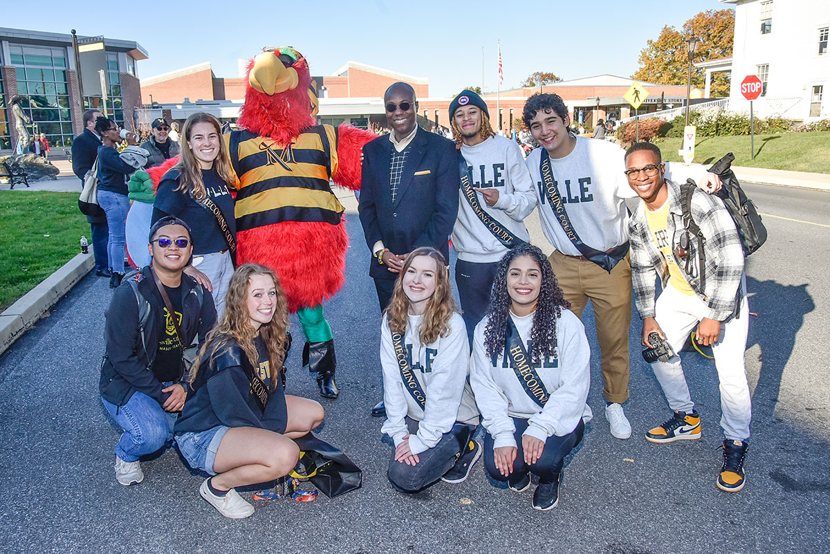 Dr. Wubah and skully pose with mu homecoming court