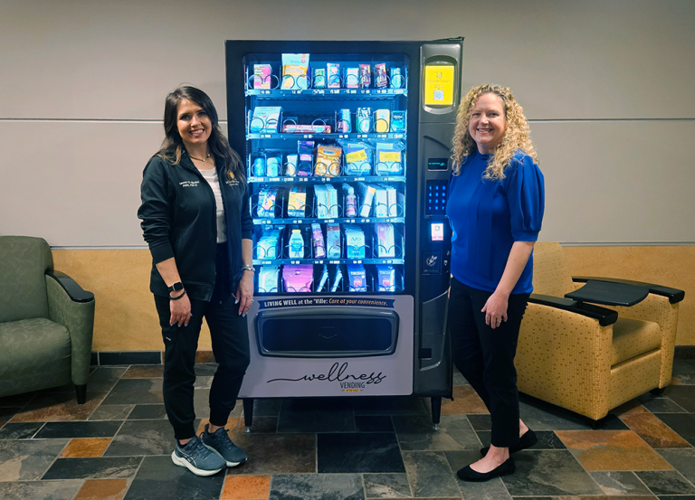 Director of health services and nurse practitioner Lauren Blevins, left, poses with Dr. Susan Moyer, associate professor in the Wehrheim School of Nursing with the wellness vending machine.