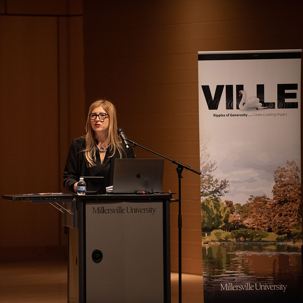 A person standing at a podium with a microphone
