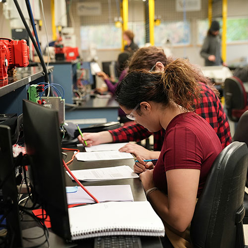 Students working together at a computer workstation in a technology lab.