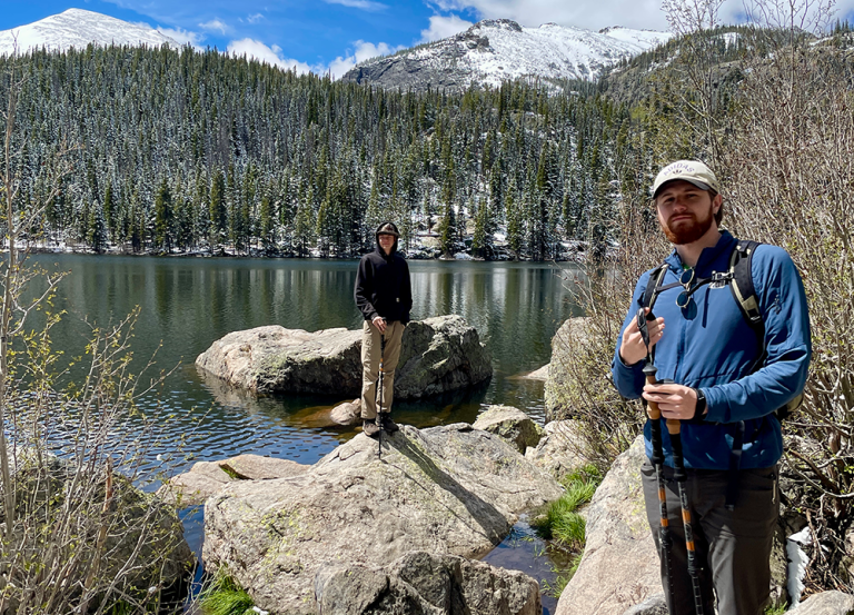 Kaden Hunter standing infront of a lake and snow capped mountains