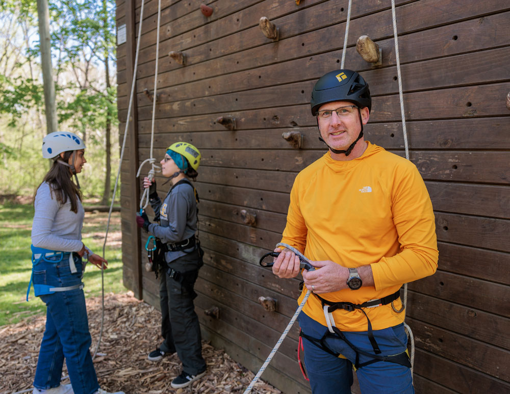 A person wearing helmet and climbing equipment