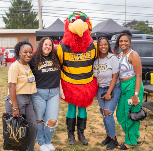 People wearing Millersville merch standing with Skully, University Mascot