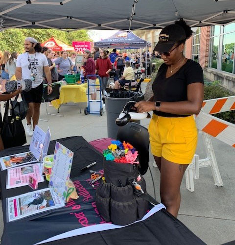 woman standing behind table at a festival