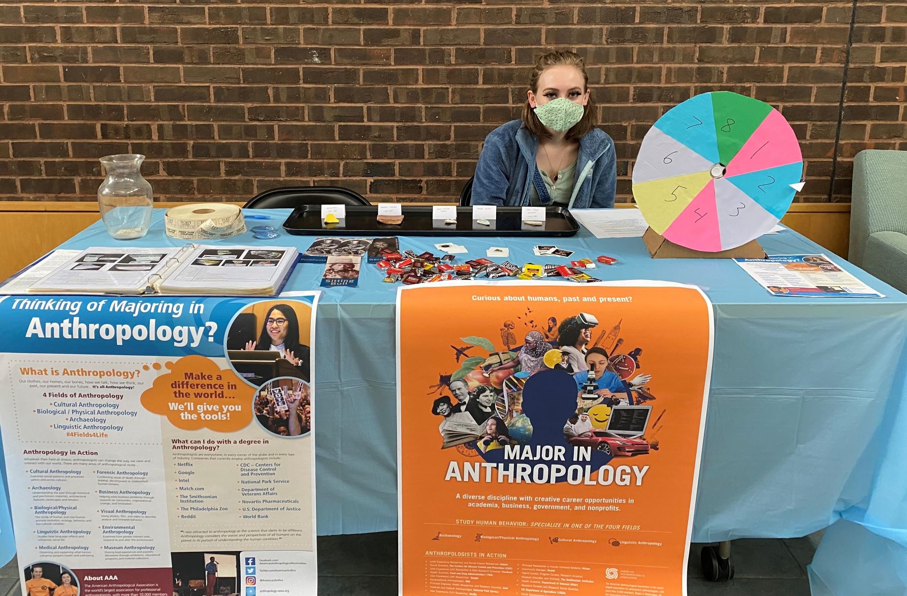 student sits at informational booth