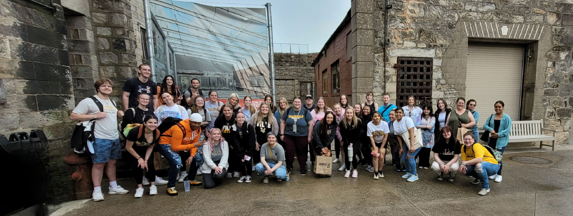 students stand in front of prison