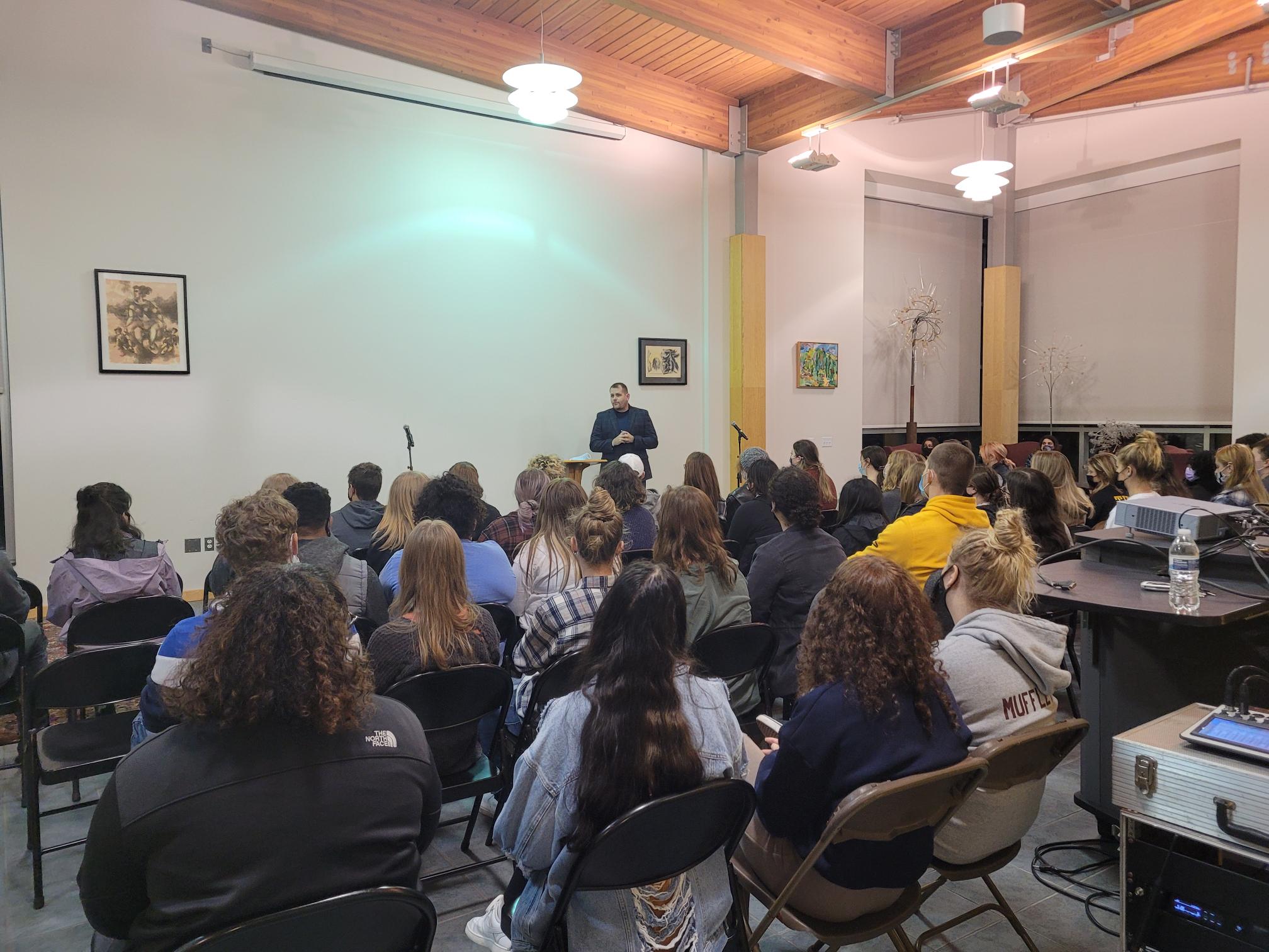 man speaks to large group