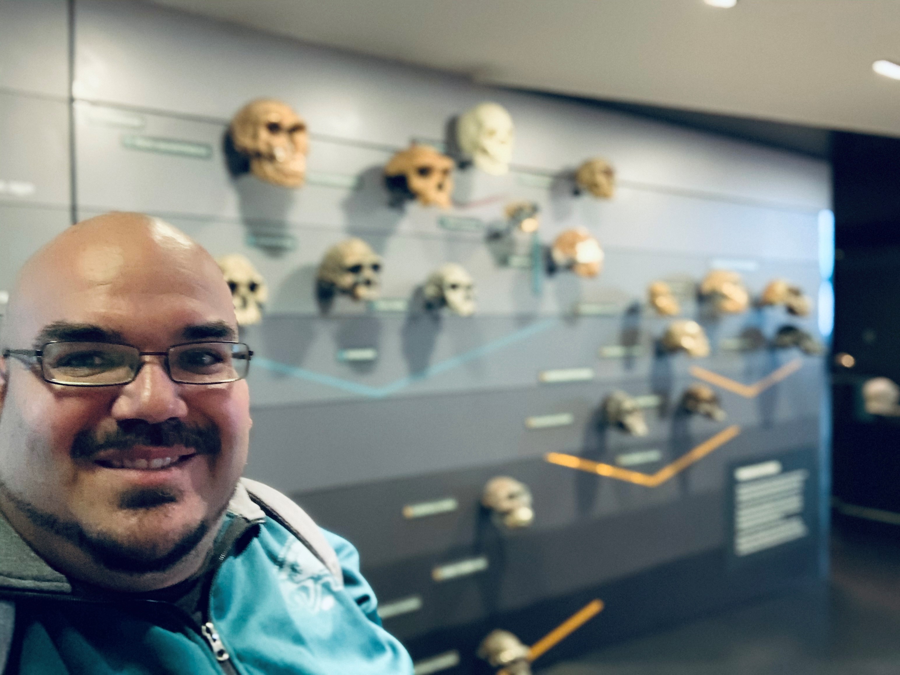 Dr Garcia with museum display of early human skulls