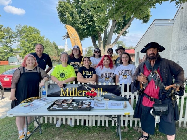 archaeology students stand with artifacts and Blackbeard reenactor