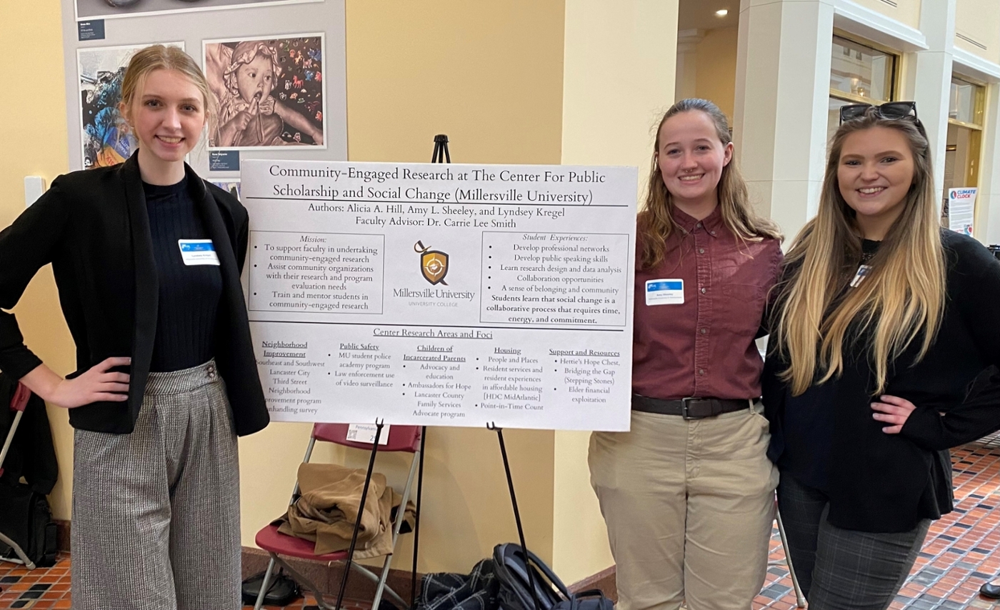 students pose with research poster