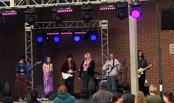 Students performing on a stage with lighting and an audience