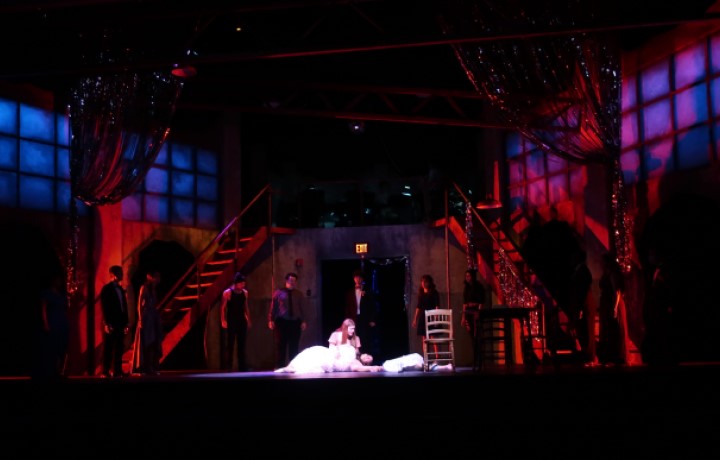 red light and shadow figures surround a mother and daughter embracing