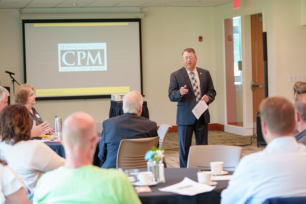 Dr. Victor DeSantis welcomes the audience to the CPM graduation